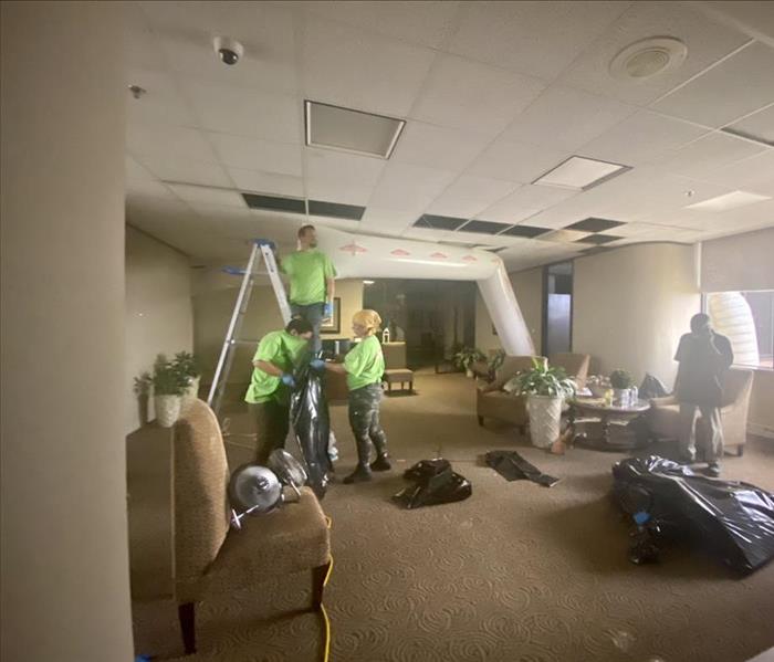 men working on a ceiling for water damage restoration 