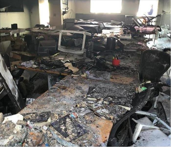 Inside of a building damaged by fire, computers, desk, chairs totally damaged by fire.